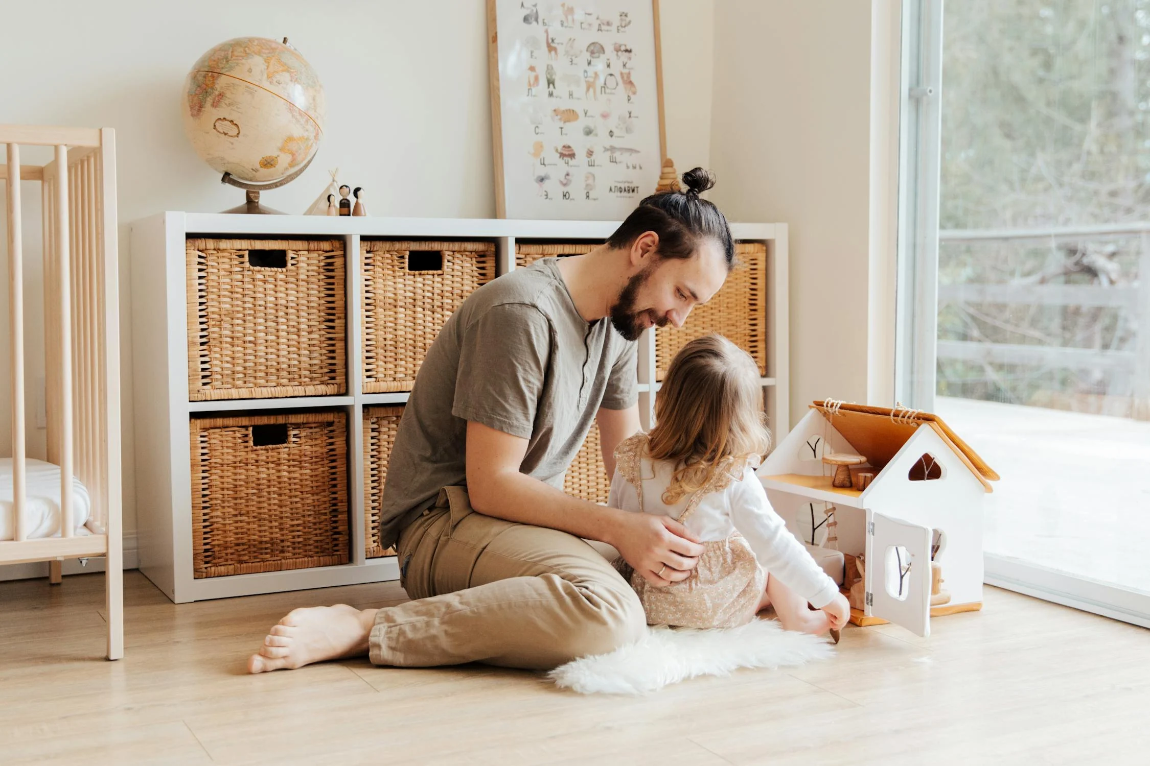 Picture of a man playing with his child in a well lit living room setting.